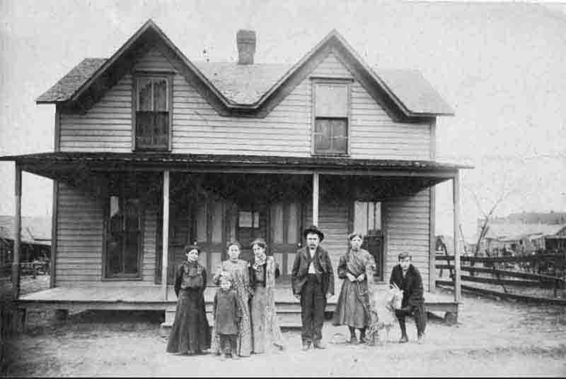 Family in front of double front doors house