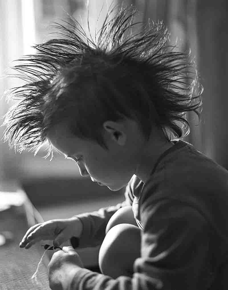 Monochrome portrait photography of a young boy with Mohawk hairstyle.