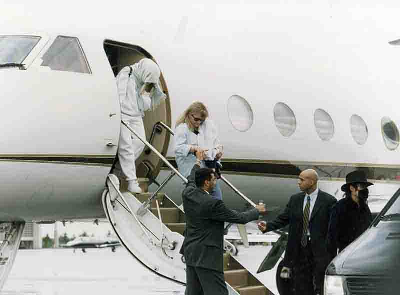 Michael Jackson and Family standing on the steps of a private jet, preparing to disembark the luxurious aircraft.