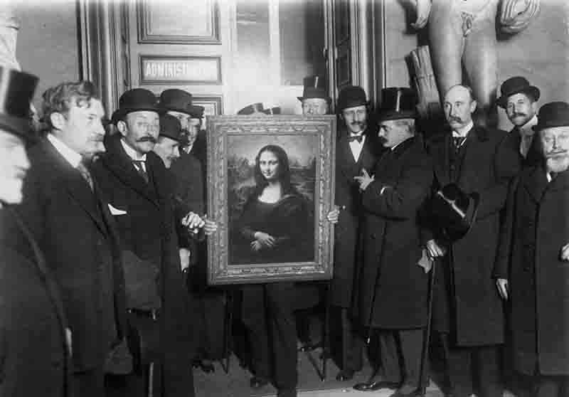 The Mona Lisa is presented to the general public by a host of detectives and museum staff following its theft from the Musée du Louvre almost two and a half years earlier.