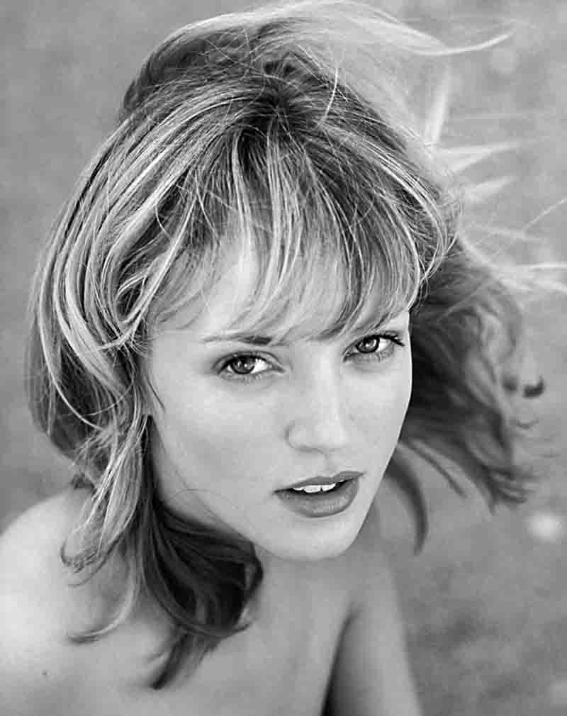 Monochrome photo portrait of a woman with wind-swept hair.